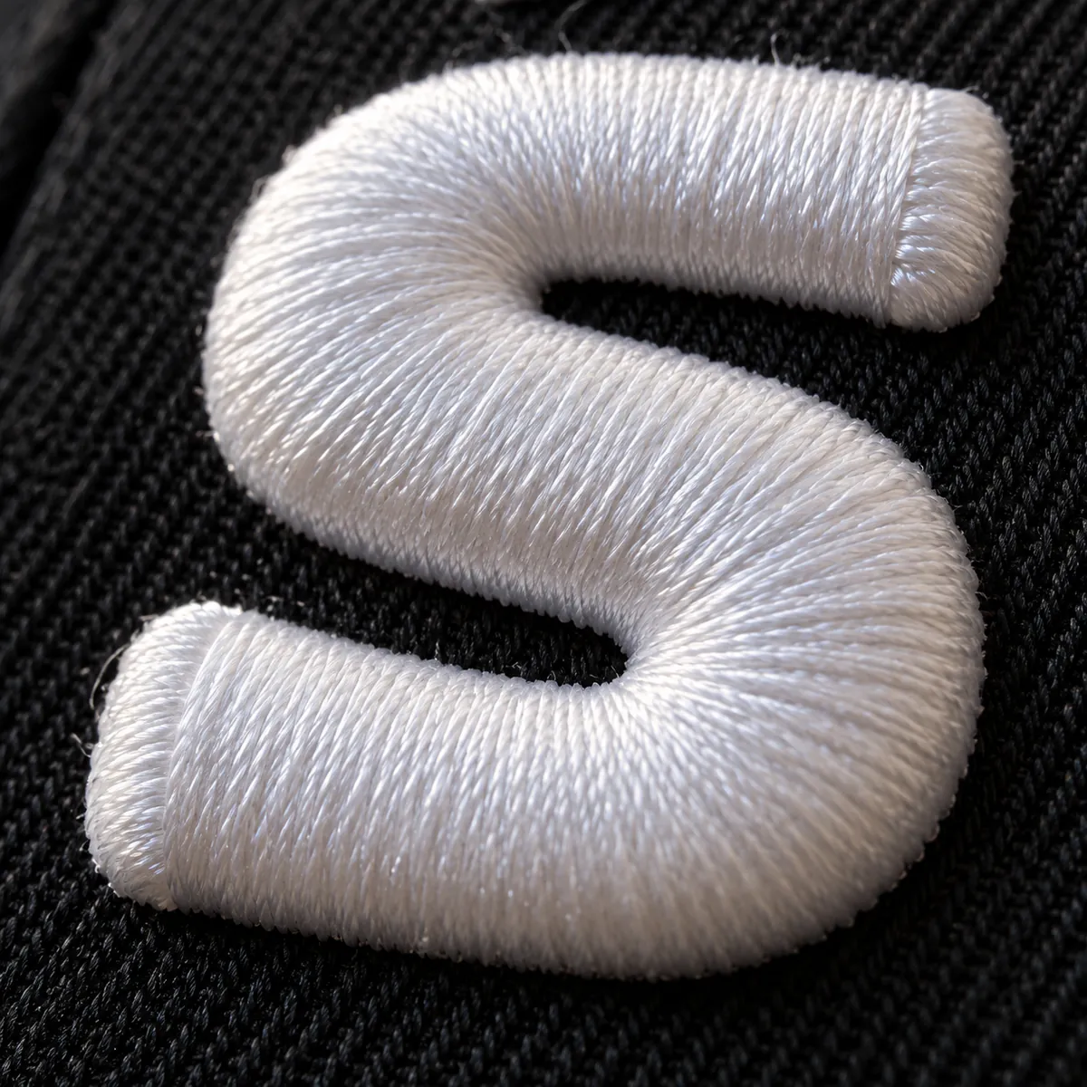 Close-up of 3D puff lettering with sealed satin ends