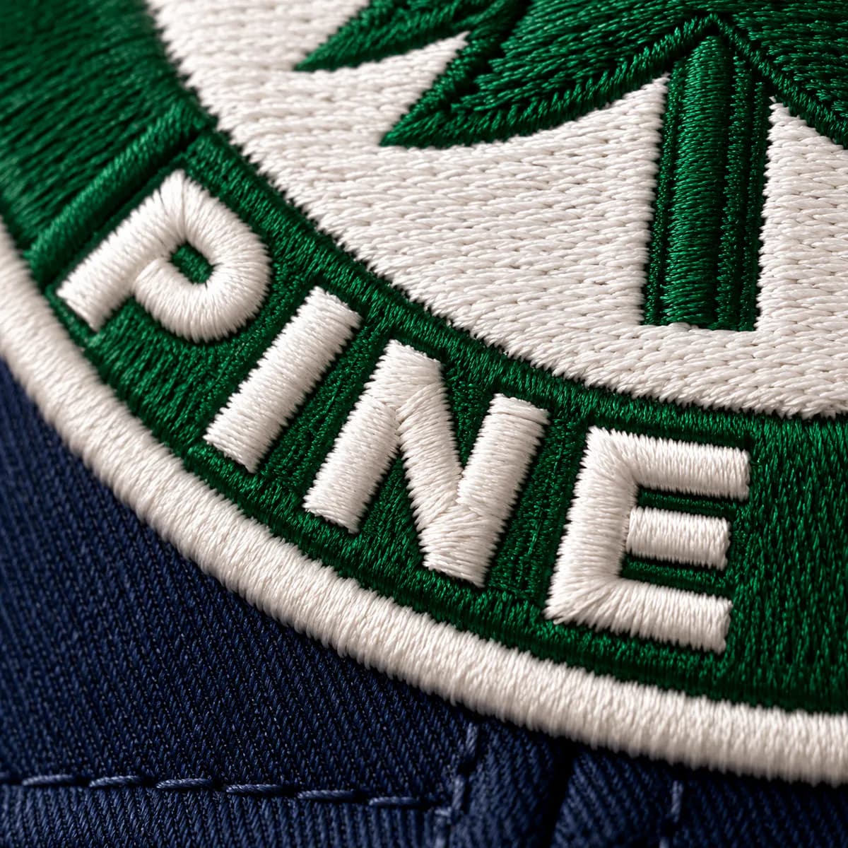 Close-up of satin-stitched lettering on an embroidered cap badge
