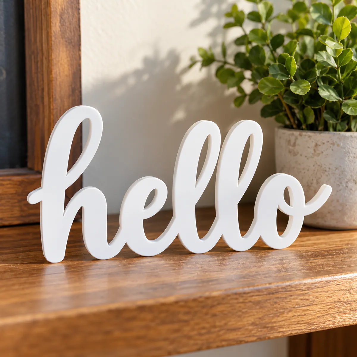 The word hello laser cut from white acrylic, on a shelf